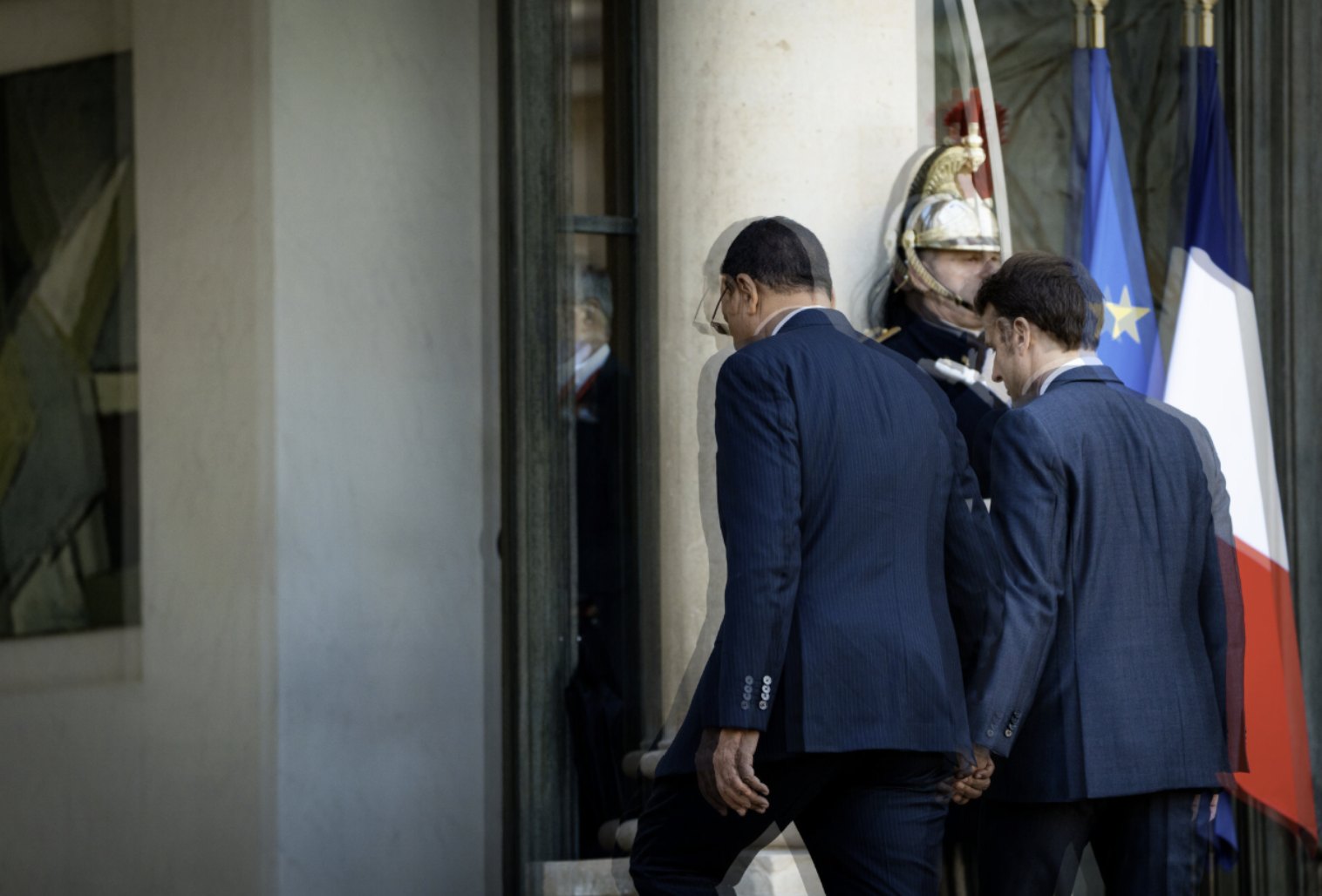 Emmanuel Macron et Mohamed Bazoum, de dos, entrant au palais de l’Élysée devant un garde républicain